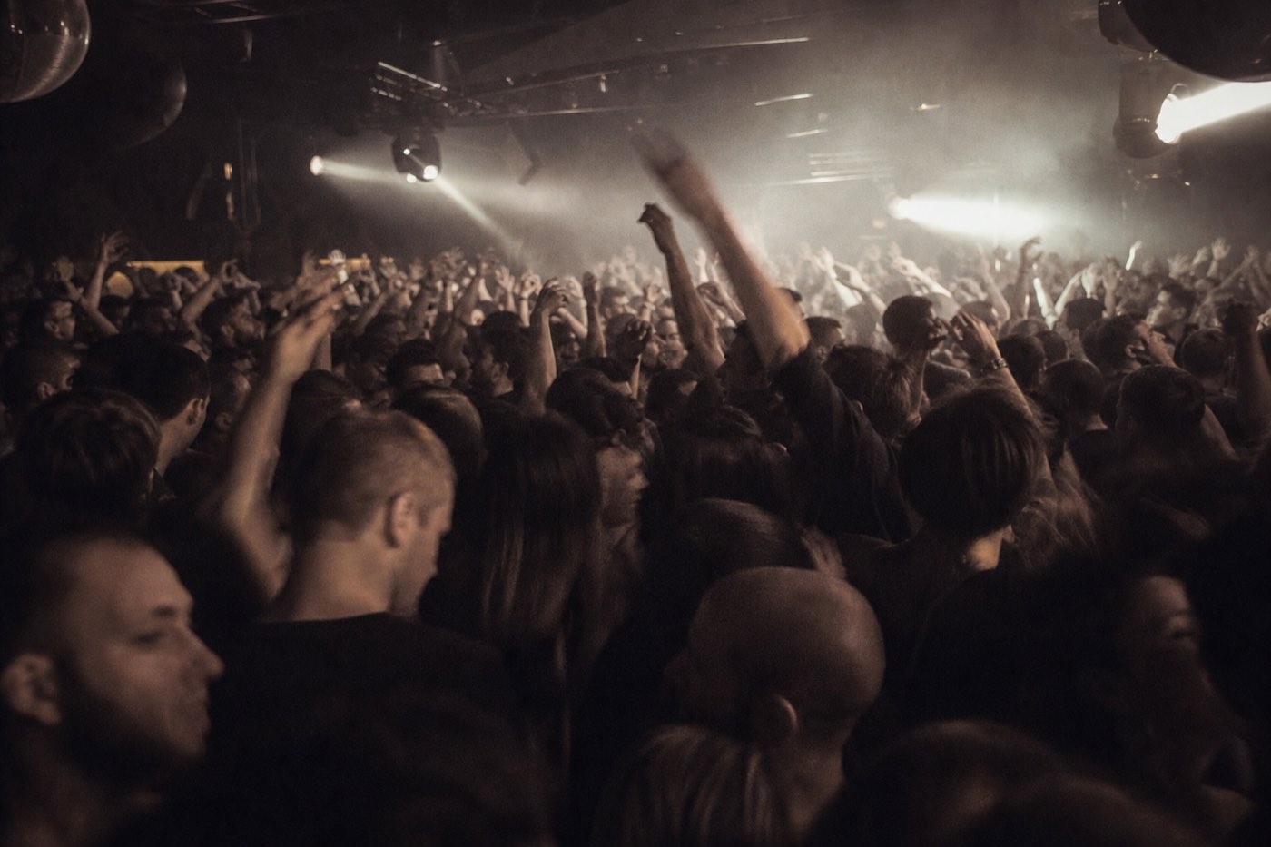 A packed, dark club dissolved in strobe and bass, the crowd blurred into a single mass.